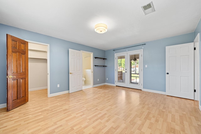 1501 Royal Palm Dr, Niceville, FL 32578 - unfurnished bedroom featuring french doors, light wood-style floors, access to exterior, baseboards, and a spacious closet