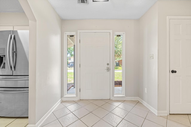 1501 Royal Palm Dr, Niceville, FL 32578 - foyer with baseboards, light tile patterned floors, and a textured ceiling