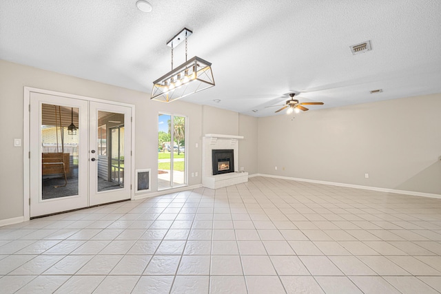 1501 Royal Palm Dr, Niceville, FL 32578 - unfurnished living room featuring a ceiling fan, a textured ceiling, french doors, baseboards, and a glass covered fireplace