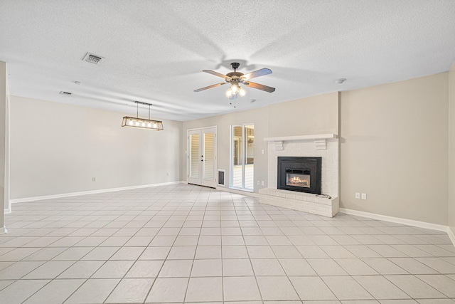 1501 Royal Palm Dr, Niceville, FL 32578 - unfurnished living room featuring baseboards, a ceiling fan, a textured ceiling, a brick fireplace, and light tile patterned flooring