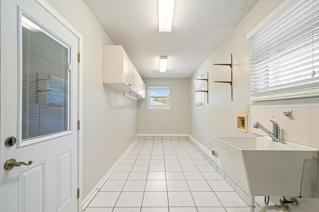 1501 Royal Palm Dr, Niceville, FL 32578 - laundry room featuring hookup for a washing machine, a textured ceiling, light tile patterned flooring, cabinet space, and baseboards