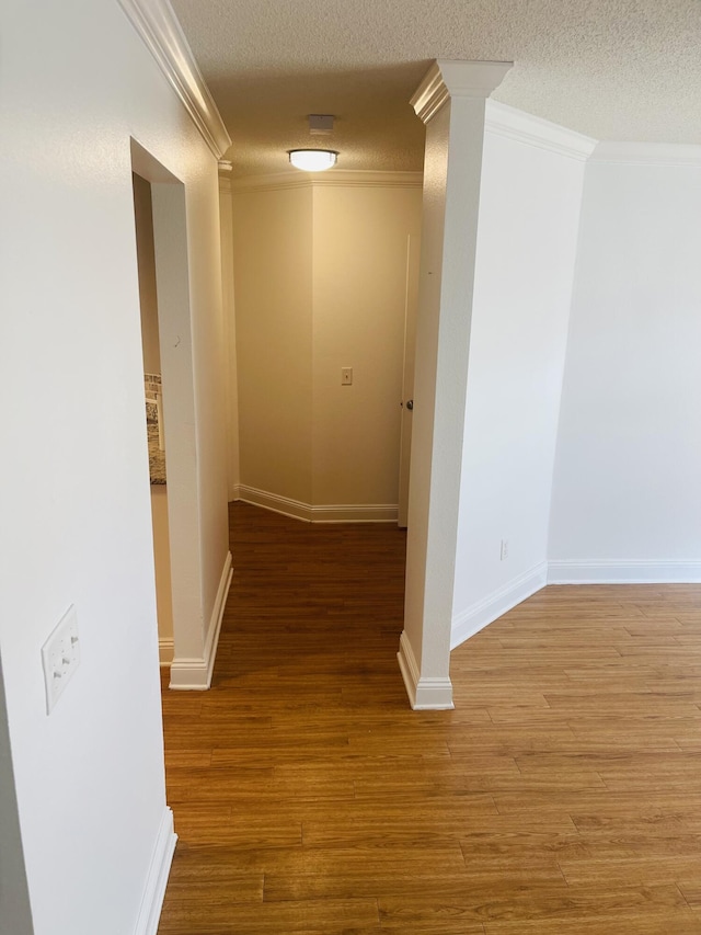 437 Hatchee Dr, Crestview, FL 32536 - hall featuring crown molding, wood finished floors, ornate columns, baseboards, and a textured ceiling