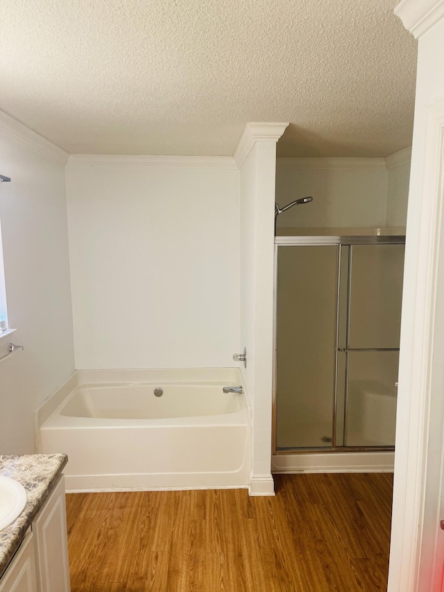 437 Hatchee Dr, Crestview, FL 32536 - bathroom featuring vanity, wood finished floors, a bath, a stall shower, and a textured ceiling