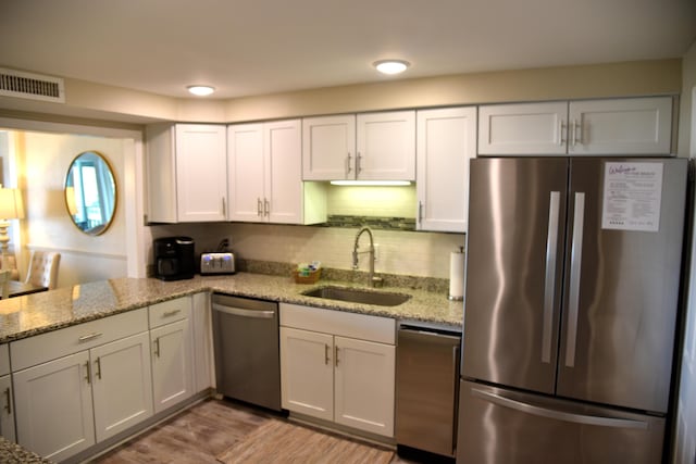 900 Gulf Shore Dr Unit 3042, Destin, FL 32541 - kitchen with stainless steel appliances, a sink, light stone countertops, and white cabinets