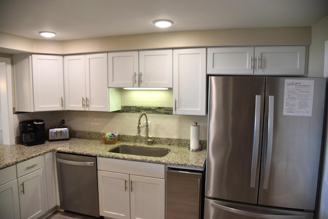 900 Gulf Shore Dr Unit 3042, Destin, FL 32541 - kitchen featuring stainless steel appliances, a sink, white cabinets, light stone counters, and tasteful backsplash