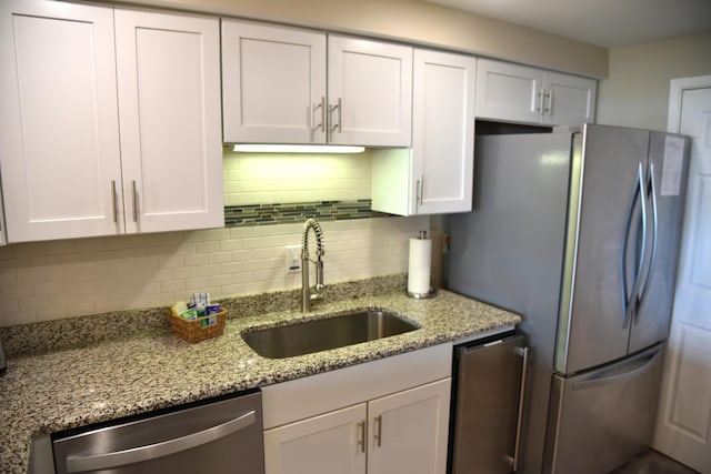 900 Gulf Shore Dr Unit 3042, Destin, FL 32541 - kitchen featuring appliances with stainless steel finishes, a sink, white cabinetry, and decorative backsplash