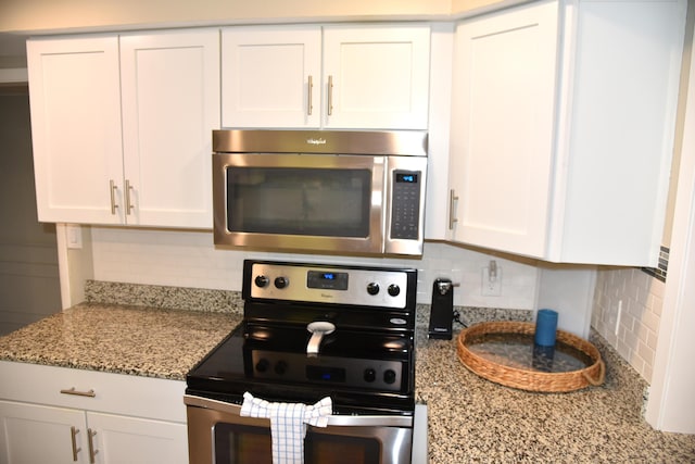 900 Gulf Shore Dr Unit 3042, Destin, FL 32541 - kitchen featuring appliances with stainless steel finishes, decorative backsplash, white cabinets, and light stone counters