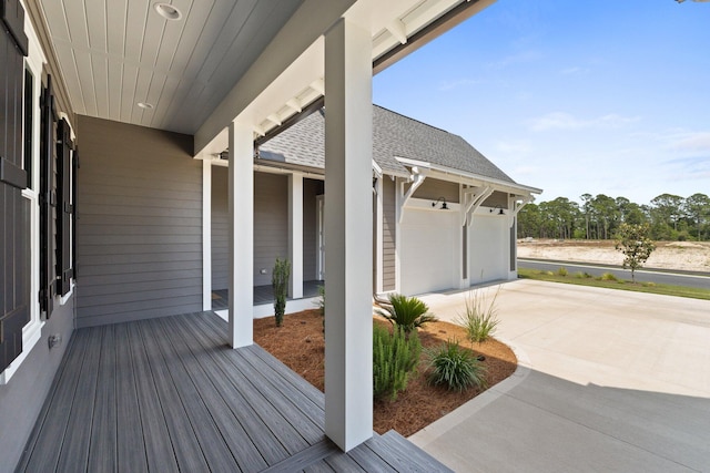 wooden terrace with a garage and driveway