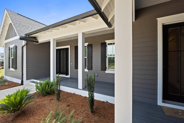 exterior space featuring covered porch and a shingled roof