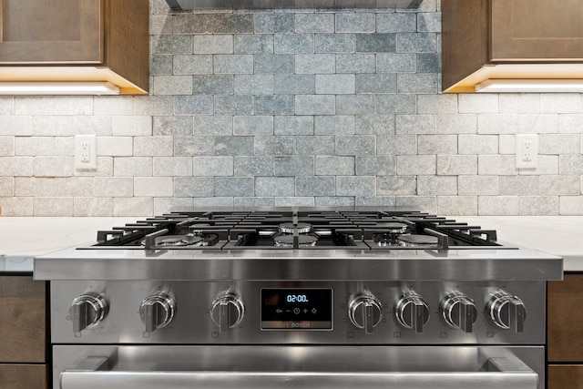 details with tasteful backsplash, brown cabinetry, and stainless steel gas stove