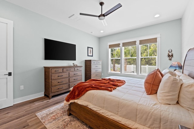bedroom with a ceiling fan, visible vents, wood finished floors, baseboards, and recessed lighting