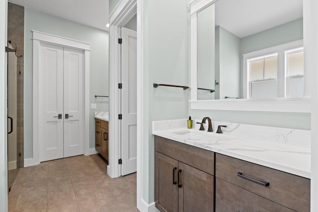 bathroom with a closet, vanity, and a stall shower