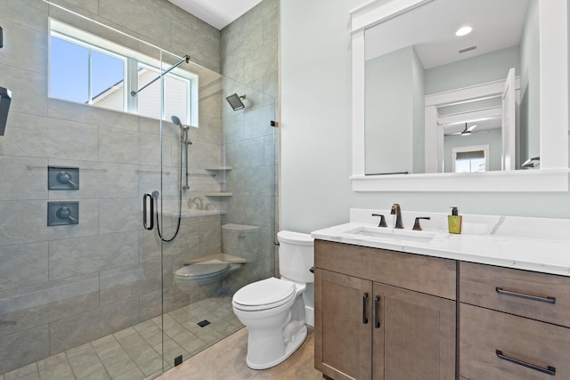 full bathroom featuring vanity, a stall shower, toilet, and a wealth of natural light