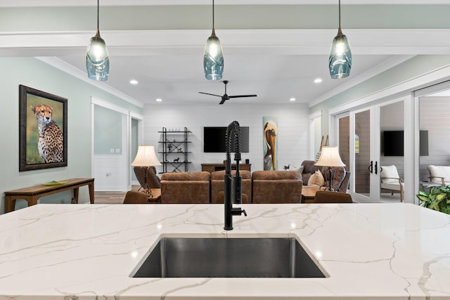 kitchen featuring a sink, open floor plan, and ornamental molding