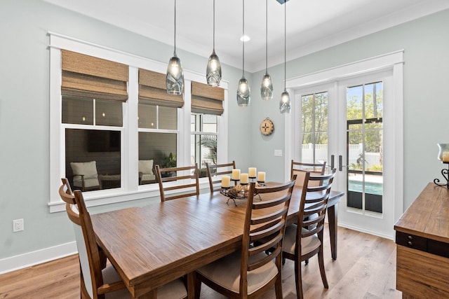 dining area with baseboards, french doors, and light wood-type flooring