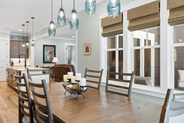 dining room featuring ornamental molding and light wood-type flooring