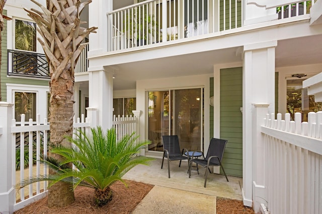 view of patio / terrace featuring fence and a balcony