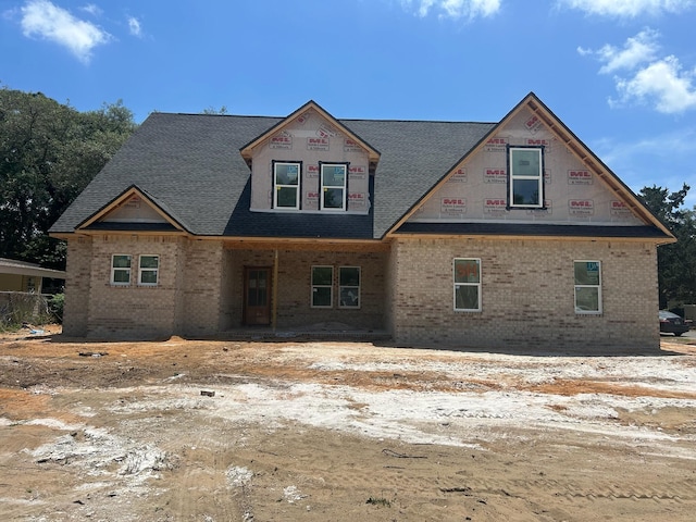 property under construction featuring roof with shingles and brick siding