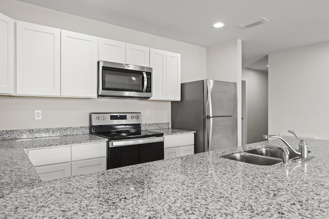 kitchen with recessed lighting, white cabinetry, appliances with stainless steel finishes, and a sink