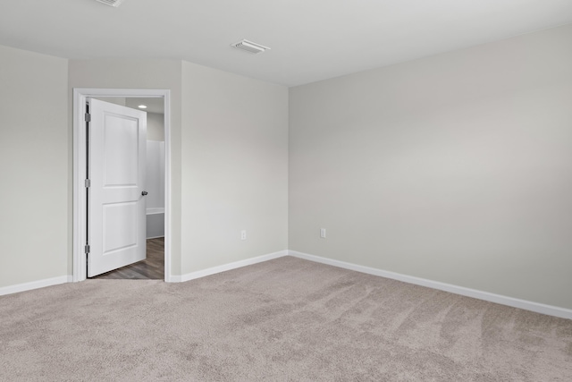 carpeted spare room with baseboards and visible vents