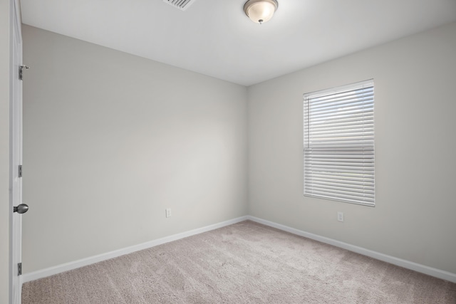 spare room featuring carpet and baseboards