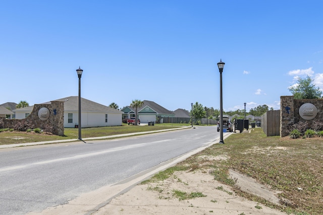 view of road with street lighting, curbs, sidewalks, and a residential view