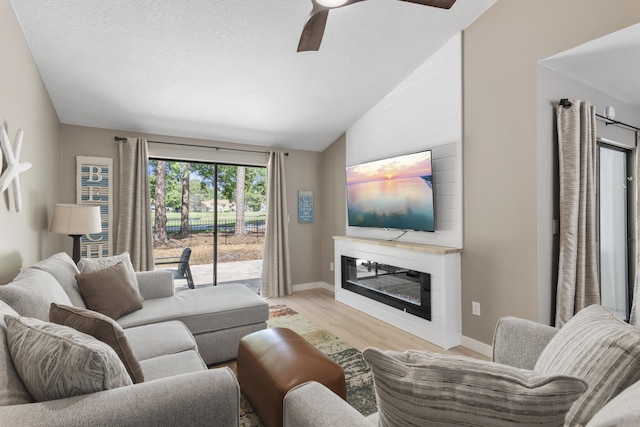 399 Linkside Dr, Miramar Beach, FL 32550 - living room with ceiling fan, wood finished floors, baseboards, vaulted ceiling, and a glass covered fireplace