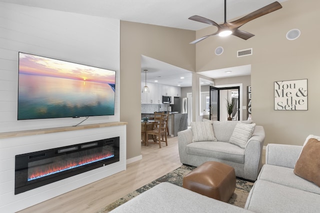 399 Linkside Dr, Miramar Beach, FL 32550 - living room featuring a fireplace, light wood-style floors, a ceiling fan, high vaulted ceiling, and recessed lighting