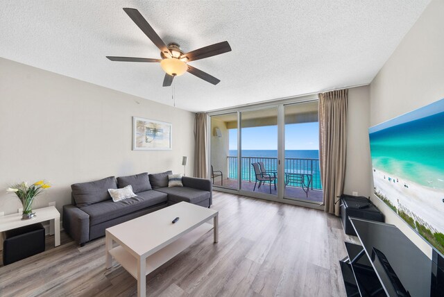 living area with a textured ceiling, ceiling fan, and wood finished floors