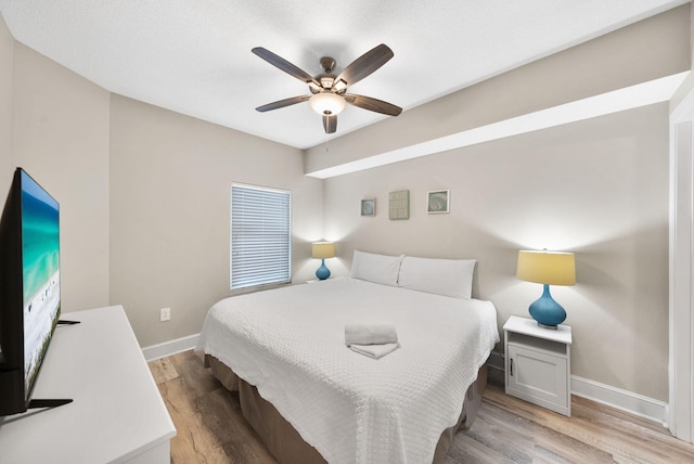 bedroom featuring baseboards, ceiling fan, and light wood finished floors