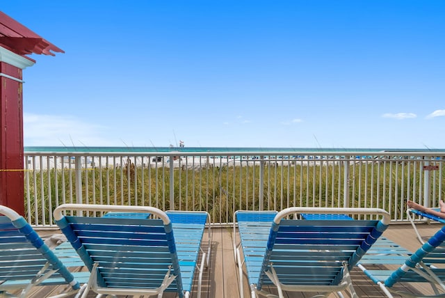 view of patio featuring a beach view, a balcony, and a water view