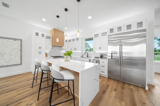 2456 Belmar Ct, Panama City Beach, FL 32408 - kitchen with a sink, a center island, stainless steel appliances, tasteful backsplash, and visible vents
