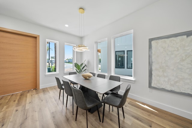 2456 Belmar Ct, Panama City Beach, FL 32408 - dining space with baseboards, wood finished floors, a healthy amount of sunlight, and an inviting chandelier