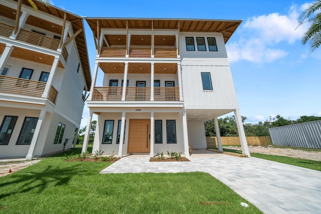2456 Belmar Ct, Panama City Beach, FL 32408 - view of front of property with driveway, a front yard, a carport, fence, and a balcony