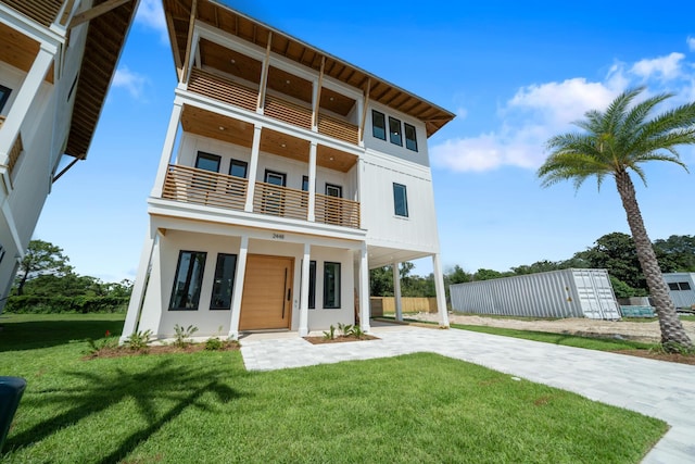 2456 Belmar Ct, Panama City Beach, FL 32408 - rear view of property featuring a yard, driveway, and a balcony