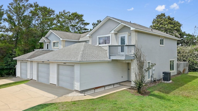 6918 Sea Turtle Cir, Navarre, FL 32566 - view of property exterior featuring driveway, roof with shingles, a lawn, a balcony, and an attached garage