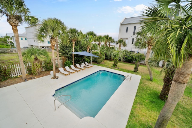 pool featuring fence, a yard, and a patio area