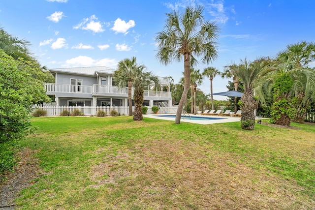 back of property featuring a fenced in pool, fence, and a yard