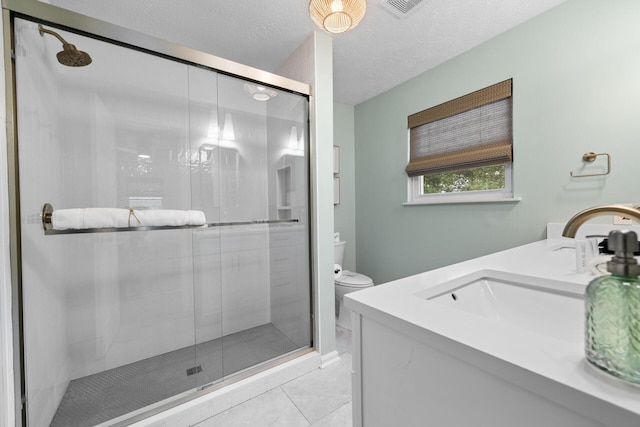 bathroom featuring vanity, toilet, a textured ceiling, a shower stall, and visible vents