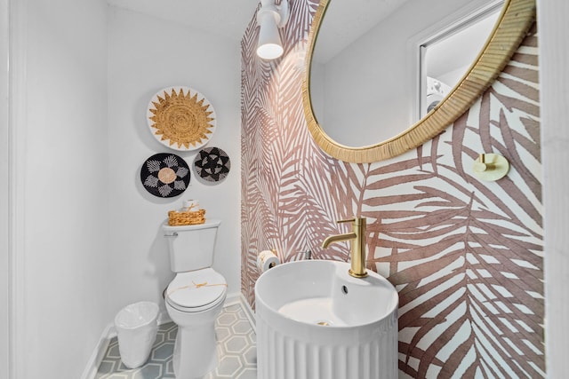bathroom with baseboards and toilet