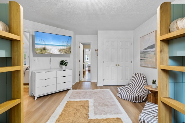 bedroom with a closet, a textured ceiling, and wood finished floors