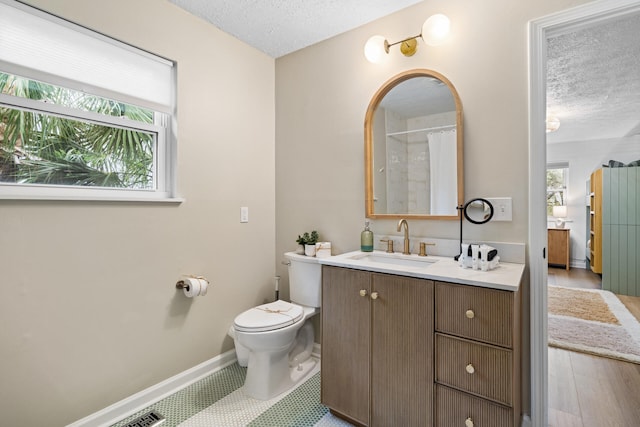 full bathroom with baseboards, vanity, toilet, and a textured ceiling