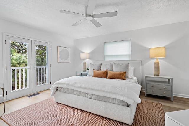 bedroom with visible vents, a textured ceiling, wood finished floors, and access to exterior