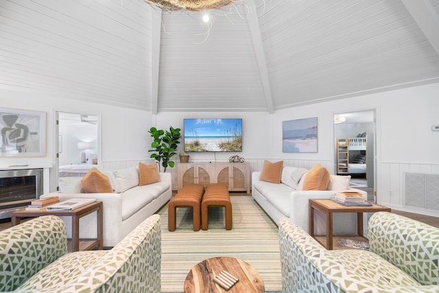 living area with vaulted ceiling with beams, wainscoting, and visible vents