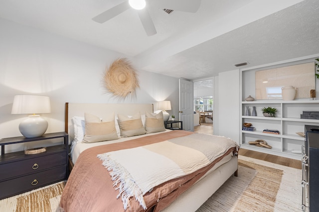 bedroom featuring ceiling fan, visible vents, and wood finished floors