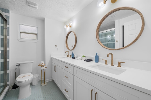full bath featuring a sink, a textured ceiling, a stall shower, and toilet