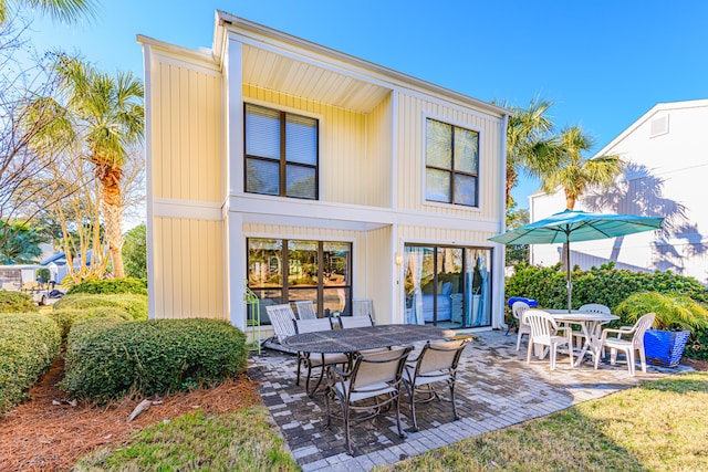 rear view of property with a patio and outdoor dining area