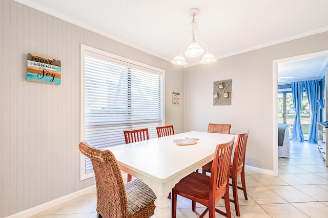 dining room with crown molding, light tile patterned floors, and baseboards