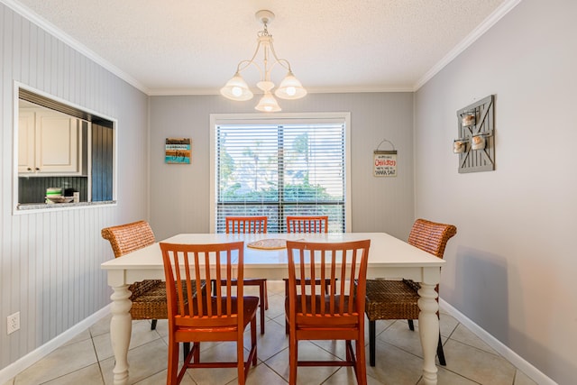 dining space with an inviting chandelier, ornamental molding, a textured ceiling, and baseboards