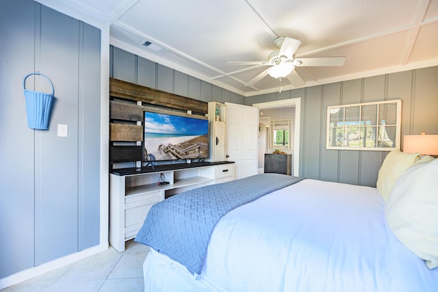 bedroom featuring a decorative wall, light tile patterned flooring, visible vents, a ceiling fan, and baseboards
